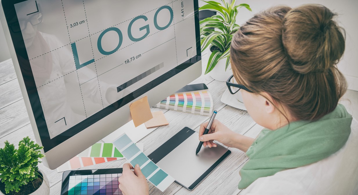 woman designing a logo on her Mac computer