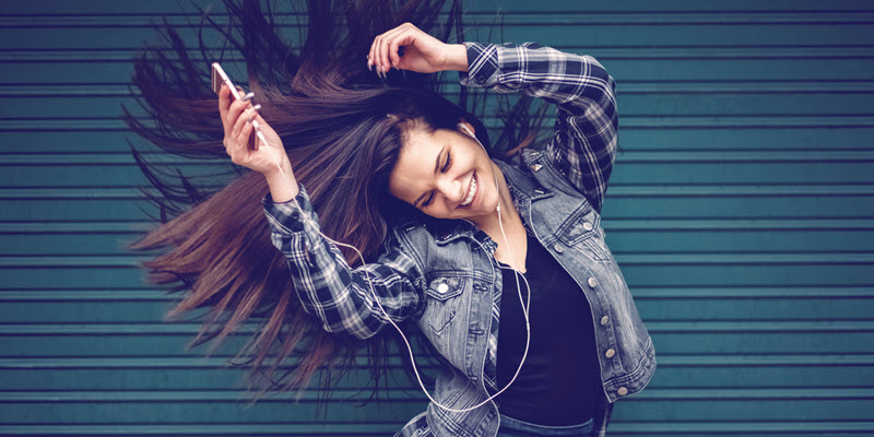 woman dancing with earbuds in