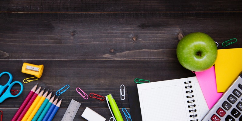 Notebook pencils and apple on desk