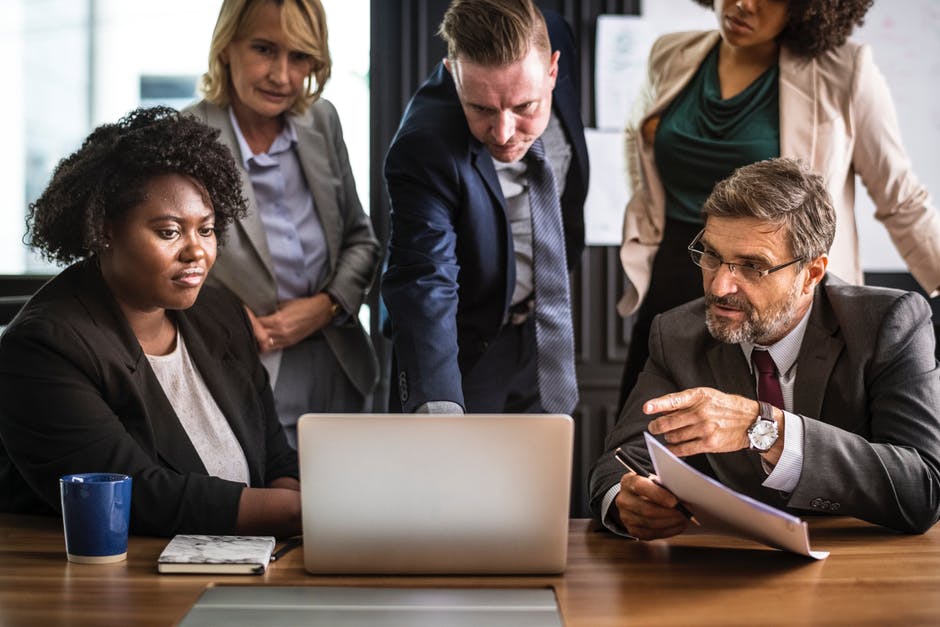 group of employees huddled around laptop